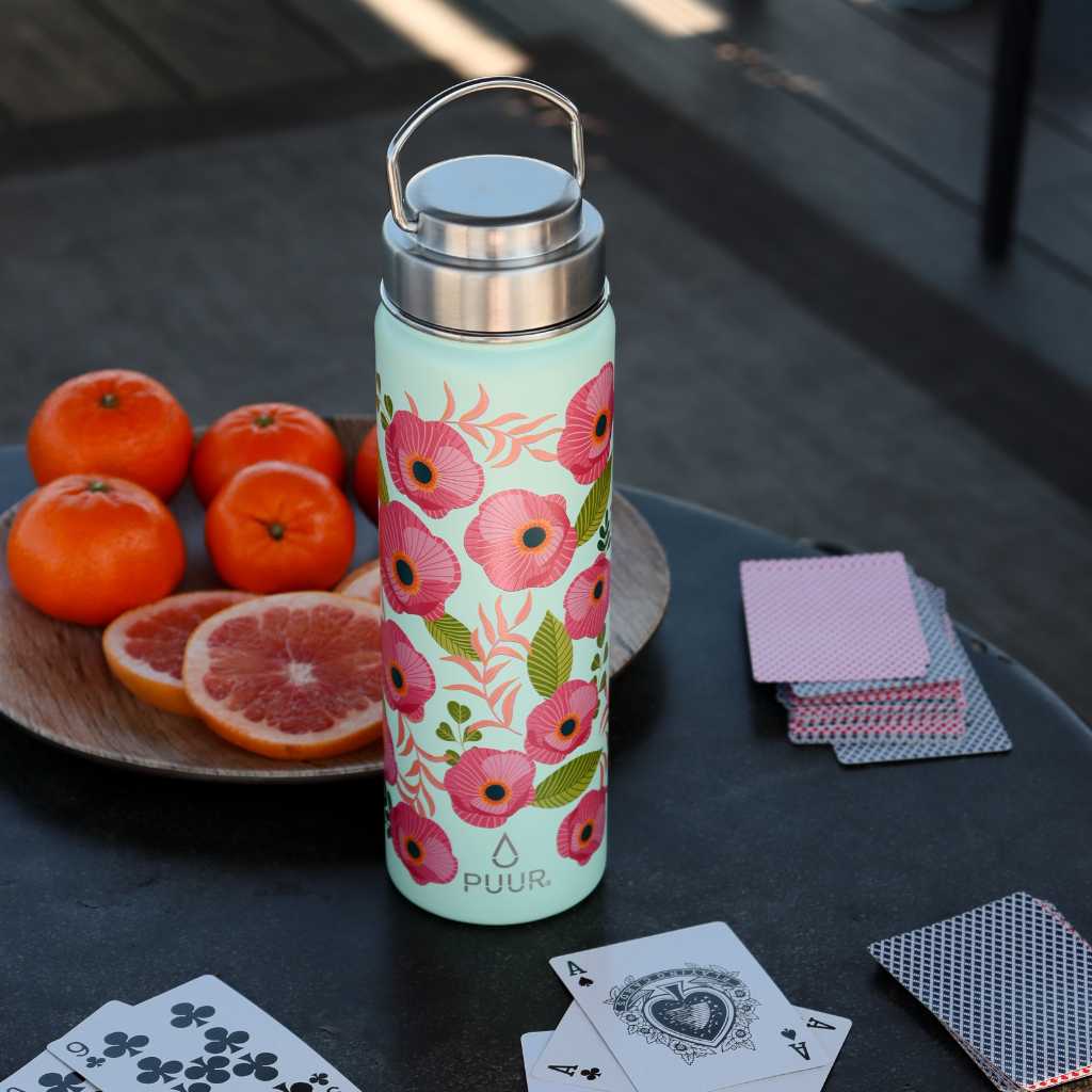 Botella Térmica Puur Activa con flores en una mesa con cartas de poker